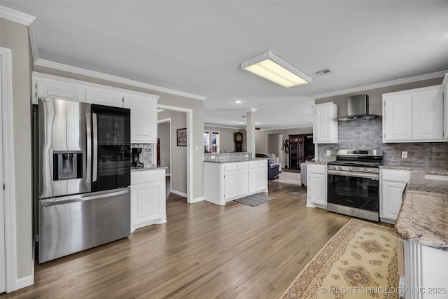 kitchen featuring crown molding, wall chimney exhaust hood, tasteful backsplash, visible vents, and appliances with stainless steel finishes