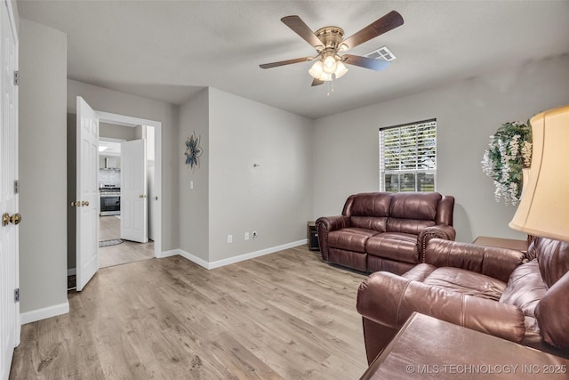 living area with light wood finished floors, visible vents, baseboards, and a ceiling fan