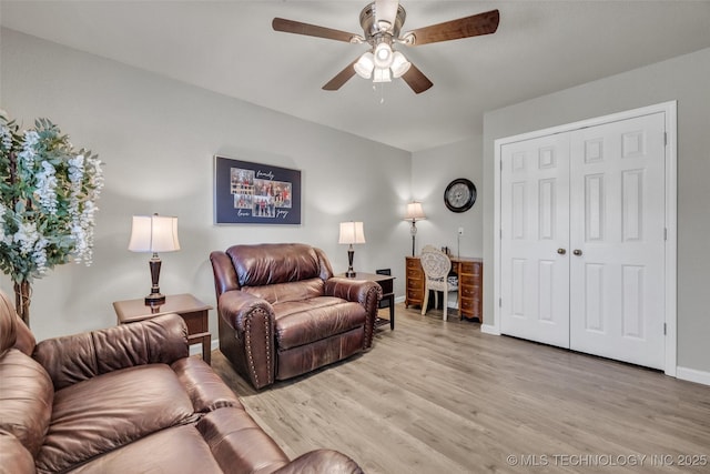living room with light wood finished floors, baseboards, and a ceiling fan