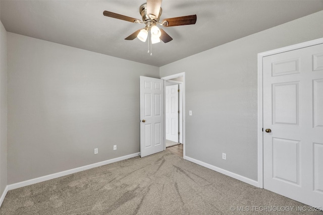unfurnished bedroom with carpet, baseboards, and a ceiling fan
