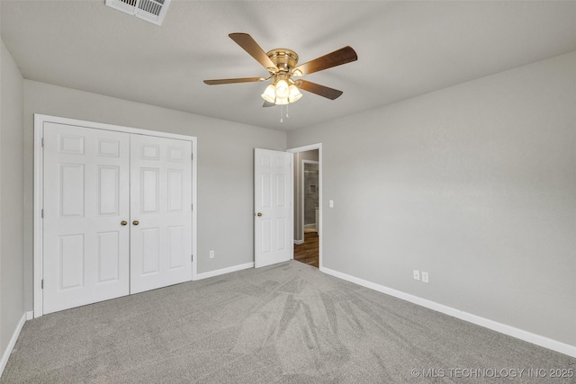 unfurnished bedroom with a closet, baseboards, carpet, and visible vents