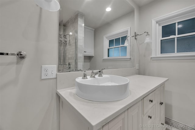 bathroom featuring a tile shower, vanity, and recessed lighting