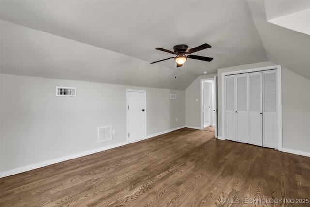 bonus room featuring dark wood finished floors, visible vents, a ceiling fan, and lofted ceiling