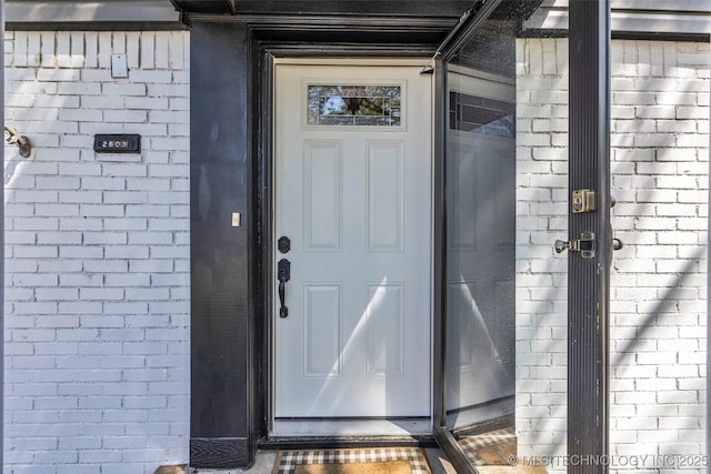 doorway to property featuring brick siding