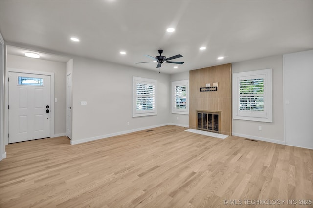 unfurnished living room with baseboards, ceiling fan, and a healthy amount of sunlight