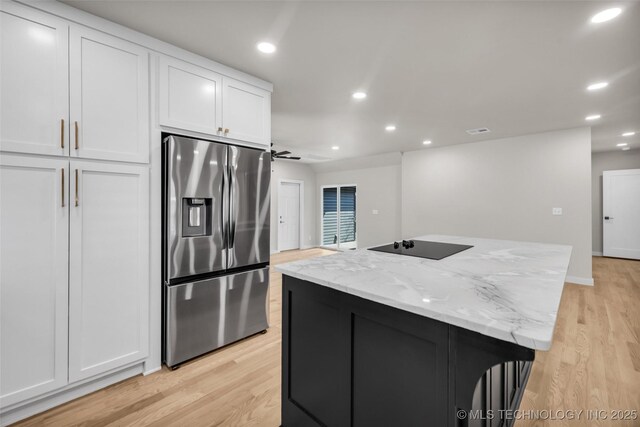 kitchen featuring stainless steel refrigerator with ice dispenser, light wood-type flooring, white cabinetry, and a kitchen island