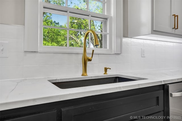 room details with a sink, backsplash, light stone counters, and dishwasher