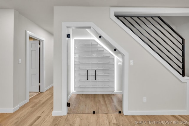 stairs featuring wood finished floors and baseboards