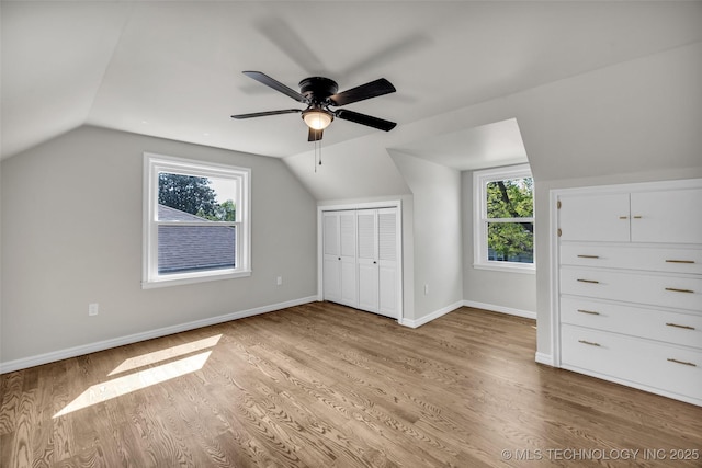 bonus room featuring baseboards, light wood finished floors, ceiling fan, and vaulted ceiling