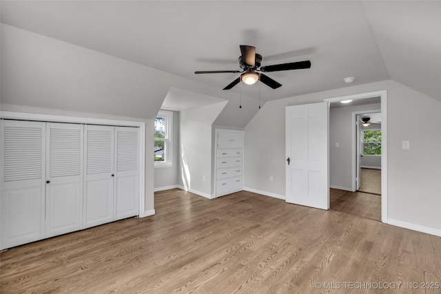 bonus room with light wood-style floors, vaulted ceiling, and a ceiling fan