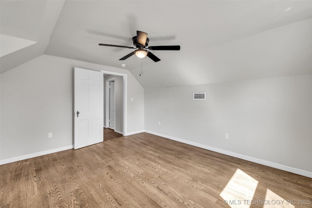 bonus room featuring baseboards, vaulted ceiling, visible vents, ceiling fan, and wood finished floors