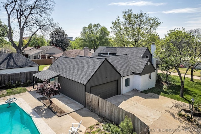 exterior space with a patio, a garage, and a chimney