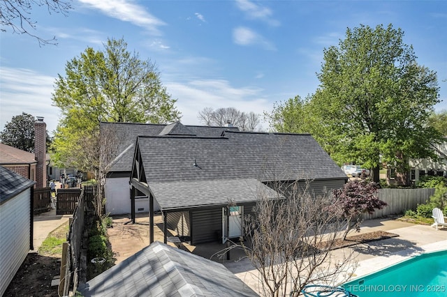 back of house with a fenced backyard, a patio, and roof with shingles