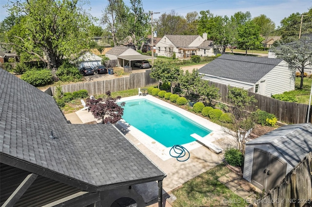 view of pool featuring a diving board, a fenced backyard, a patio area, a fenced in pool, and a residential view