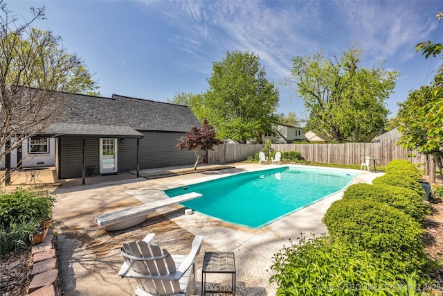 view of pool with a patio, a fenced backyard, a fenced in pool, and a diving board