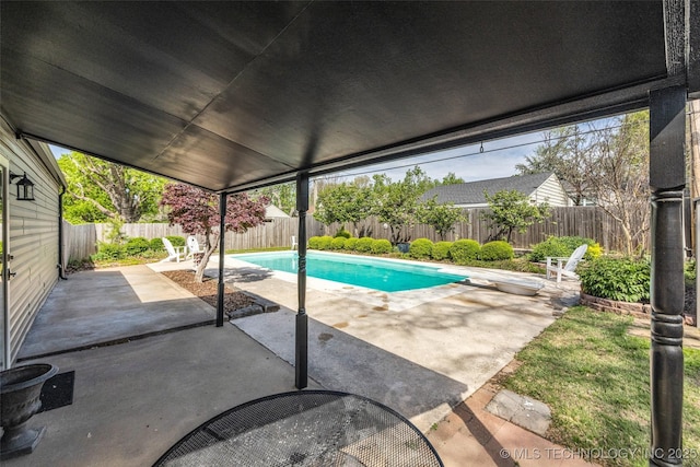 view of pool featuring a fenced in pool, a diving board, a patio area, and a fenced backyard
