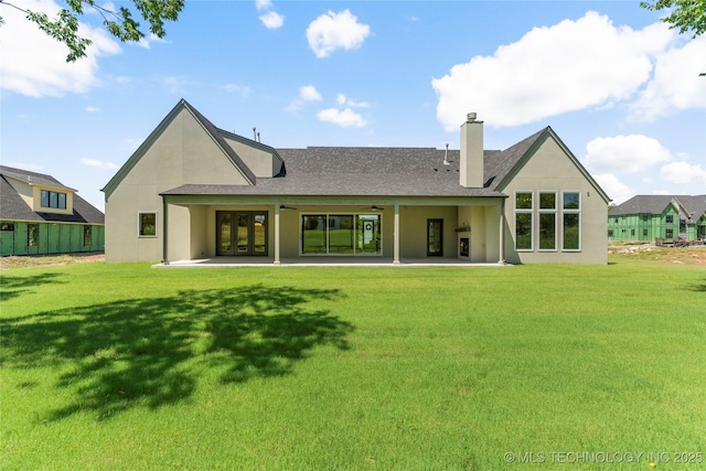 17822 E Patriot Dr, Owasso, OK 74055 - rear view of house with a lawn, stucco siding, and a chimney