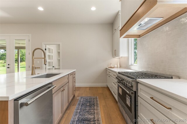 17822 E Patriot Dr, Owasso, OK 74055 - kitchen featuring stainless steel appliances, decorative backsplash, light wood finished floors, recessed lighting, and an island with sink