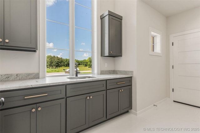 17822 E Patriot Dr, Owasso, OK 74055 - kitchen featuring gray cabinets, light stone counters, and light tile patterned floors
