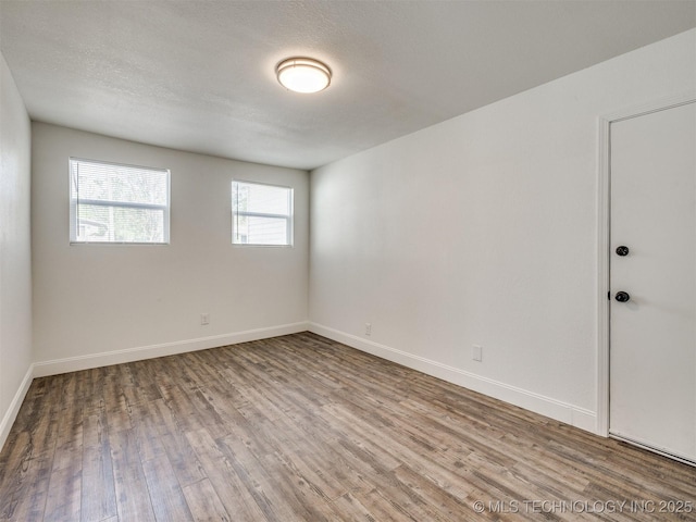empty room featuring baseboards and wood finished floors