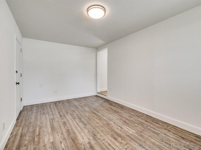 empty room with baseboards and wood finished floors