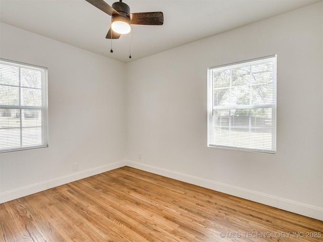 spare room featuring a ceiling fan, baseboards, a healthy amount of sunlight, and light wood-type flooring