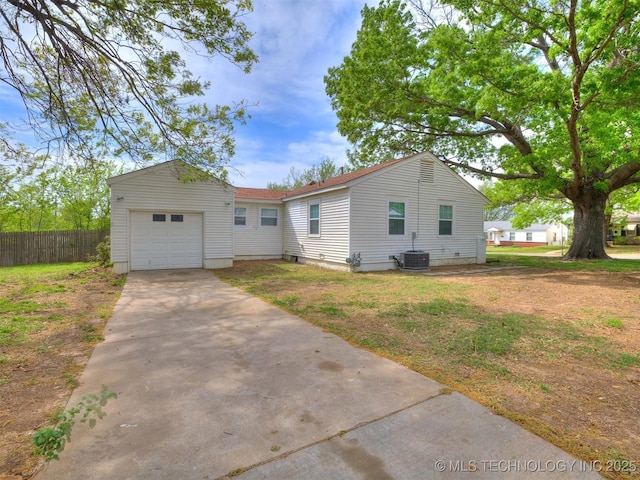 view of front facade featuring concrete driveway, fence, and central AC