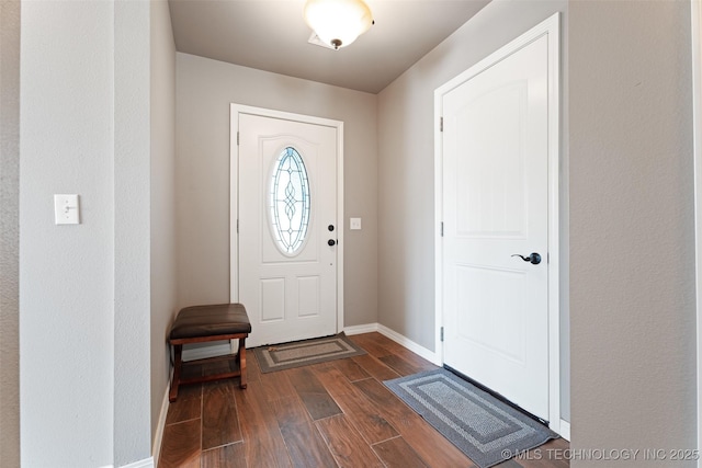 foyer featuring dark wood-style flooring and baseboards