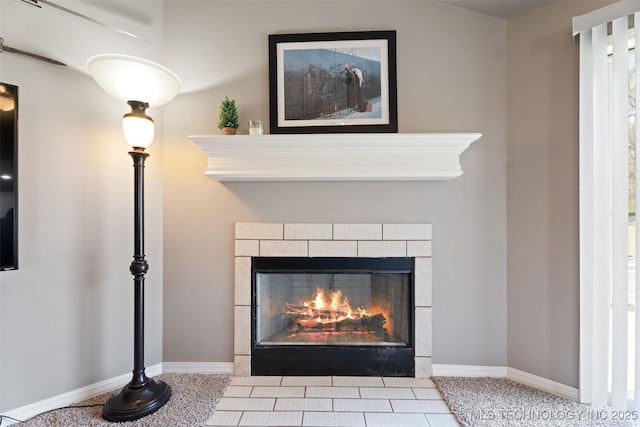room details with a tiled fireplace and baseboards
