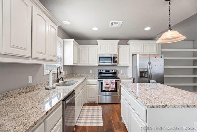 kitchen with dark wood finished floors, white cabinetry, visible vents, a sink, and stainless steel appliances