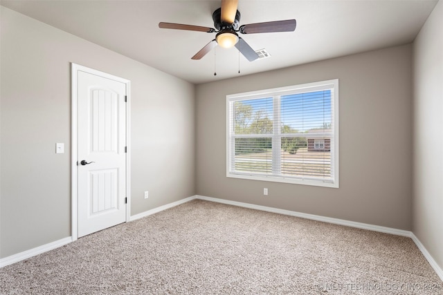 spare room with visible vents, baseboards, a ceiling fan, and carpet flooring