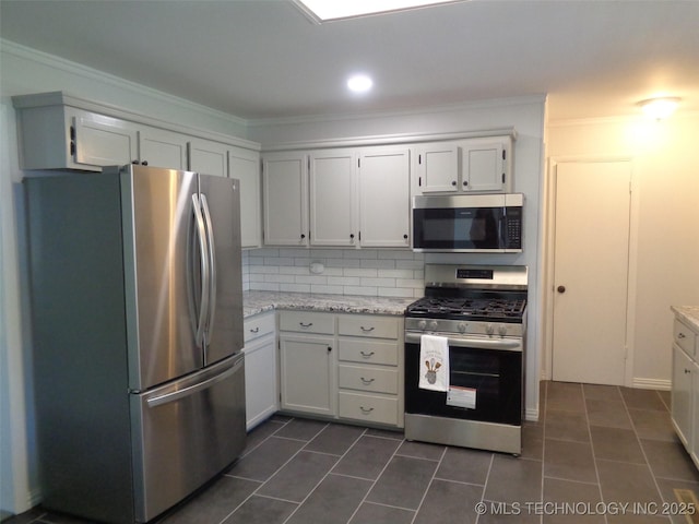 16893 E 116th St N, Owasso, OK 74055 - kitchen featuring white cabinets, appliances with stainless steel finishes, crown molding, dark tile patterned flooring, and decorative backsplash