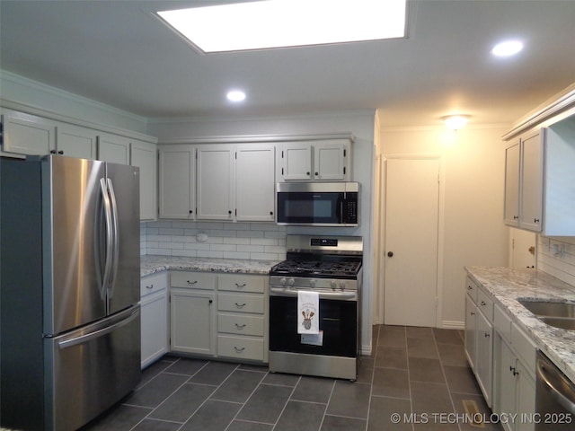 16893 E 116th St N, Owasso, OK 74055 - kitchen featuring dark tile patterned floors, ornamental molding, light stone counters, decorative backsplash, and appliances with stainless steel finishes
