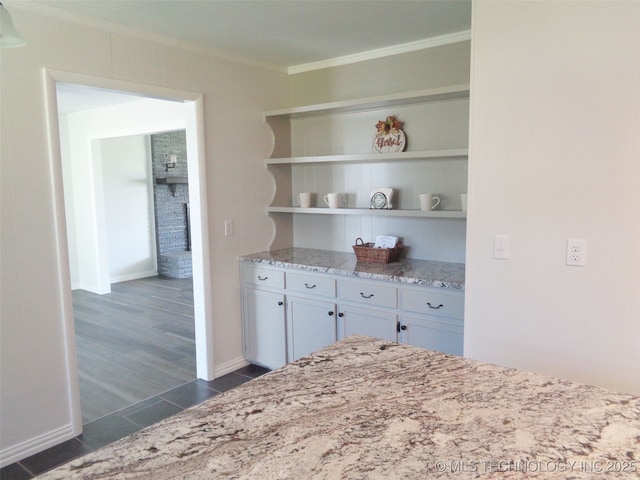 16893 E 116th St N, Owasso, OK 74055 - kitchen featuring light stone countertops, dark tile patterned flooring, open shelves, ornamental molding, and baseboards