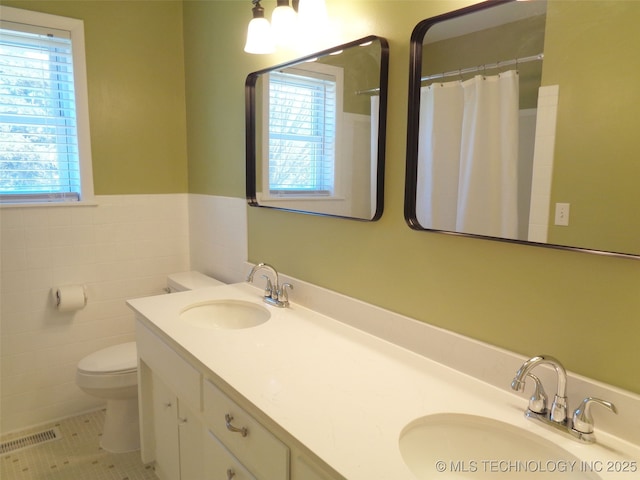 16893 E 116th St N, Owasso, OK 74055 - bathroom with a sink, toilet, double vanity, and a wainscoted wall