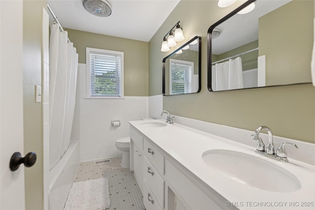 16893 E 116th St N, Owasso, OK 74055 - bathroom featuring double vanity, shower / bath combination with curtain, tile walls, wainscoting, and tile patterned floors