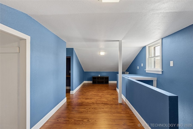 16893 E 116th St N, Owasso, OK 74055 - bonus room featuring wood finished floors, lofted ceiling, and a textured ceiling