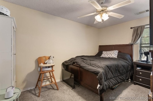 carpeted bedroom with baseboards, visible vents, a textured ceiling, and ceiling fan