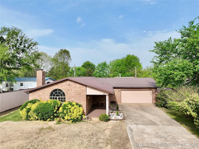 351 Hamilton Rd, Eufaula, OK 74432 - view of front facade featuring a chimney, metal roof, concrete driveway, brick siding, and a garage
