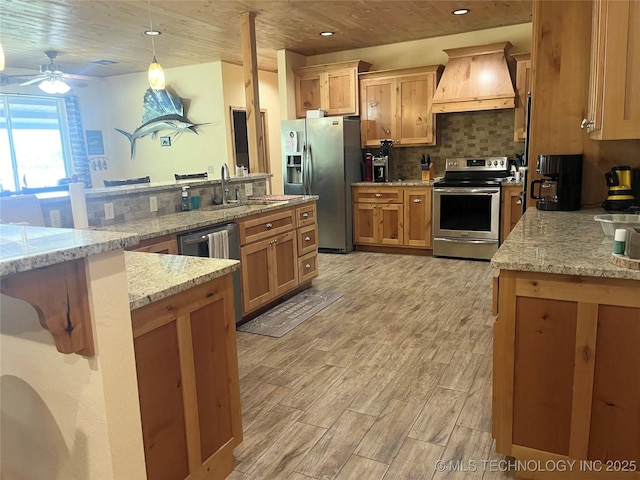 107349 S 4091st Rd, Checotah, OK 74426 - kitchen with light wood-type flooring, custom exhaust hood, light stone counters, stainless steel appliances, and decorative backsplash