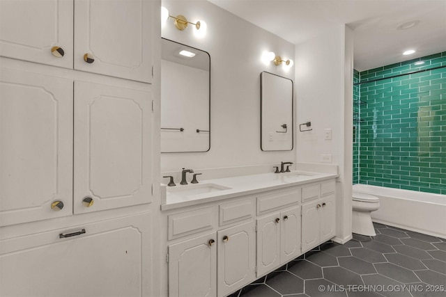 bathroom with a sink, tile patterned flooring, toilet, and double vanity