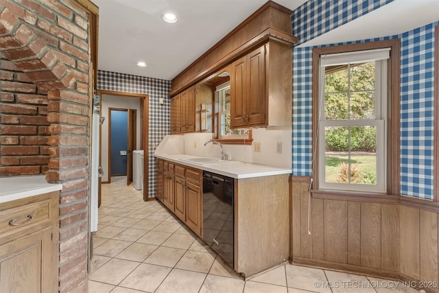 kitchen featuring a sink, black dishwasher, light countertops, and wallpapered walls