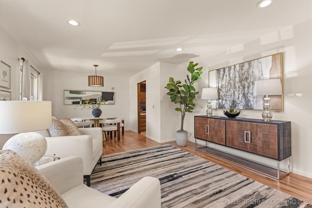 living room with recessed lighting, baseboards, and wood finished floors