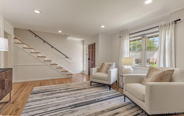 sitting room with light wood-type flooring, stairway, and recessed lighting