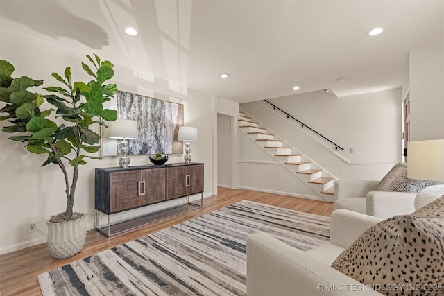 living area featuring stairs, baseboards, recessed lighting, and wood finished floors