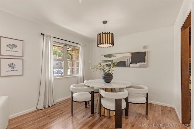 dining area featuring baseboards and light wood-style floors