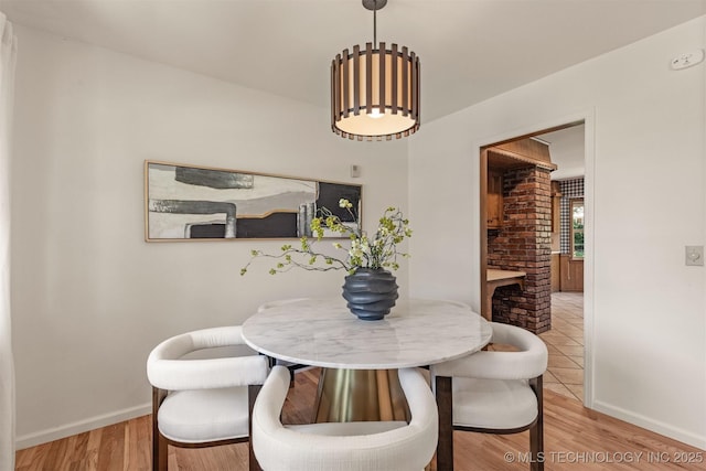 dining area with baseboards and wood finished floors