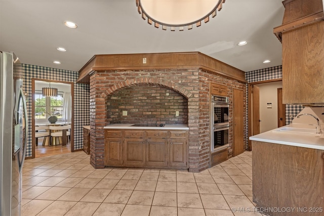 kitchen with light tile patterned floors, a sink, stainless steel appliances, light countertops, and recessed lighting