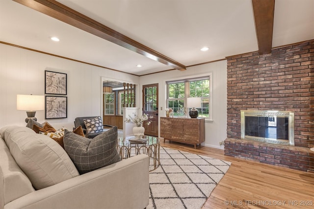 living room with recessed lighting, a brick fireplace, light wood-type flooring, and beam ceiling