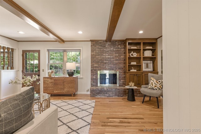 living area with a fireplace, beam ceiling, recessed lighting, and wood finished floors